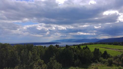 an aerial view of a green field and a lake at Auberge de nos Aieux in Les Éboulements