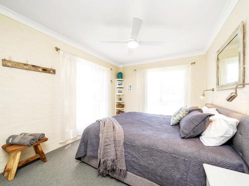 Un dormitorio con una cama grande y una ventana en Kalimna by Experience Jervis Bay, en Vincentia
