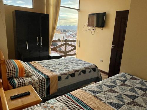 a hotel room with two beds and a balcony at Apartment with beautiful landscape in Sucre