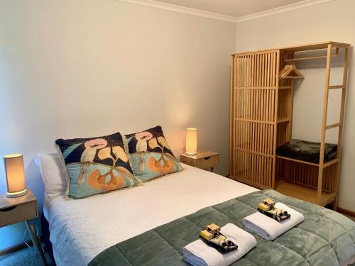 a bedroom with a bed with towels on it at Wintersun Holiday Cottages in Emu Bay