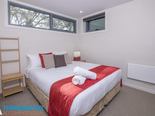 a bedroom with a bed with two towels on it at Golden Eagle 1 in Thredbo
