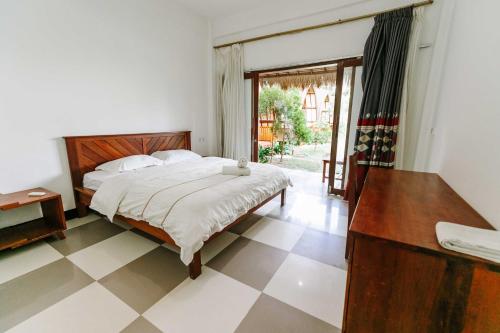 a bedroom with a bed and a table and a window at Dream CoWork Hotel in Kuta Lombok