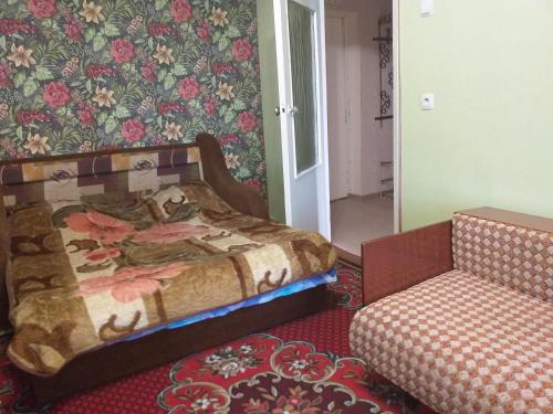 a bedroom with a bed and a chair in it at Уютная квартира не далеко от центра города in Penza