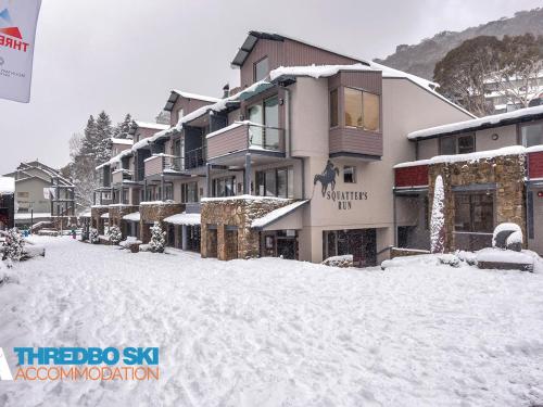 eine schneebedeckte Straße vor einem Gebäude in der Unterkunft Squatters Run 12 in Thredbo