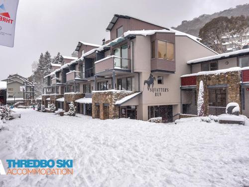 a snow covered street in front of a building at Squatters Run 12 in Thredbo