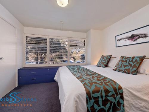 a bedroom with a large bed and two windows at Talgara 2 in Thredbo