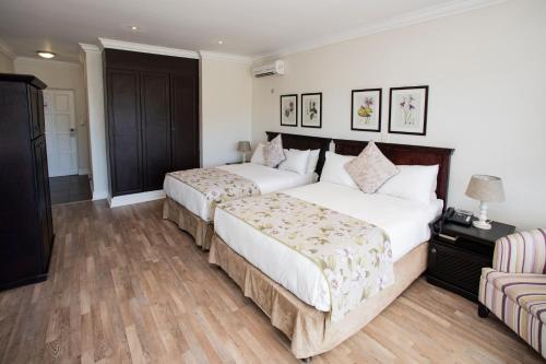 a hotel room with two beds and a couch at The Estuary Hotel & Spa in Port Edward