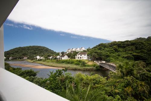 a view of a river with a bridge and houses at The Estuary Hotel & Spa in Port Edward