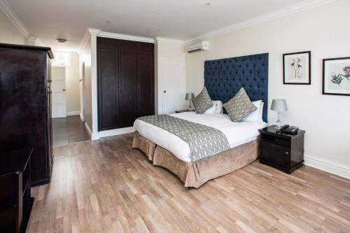 a bedroom with a large bed with a blue headboard at The Estuary Hotel & Spa in Port Edward