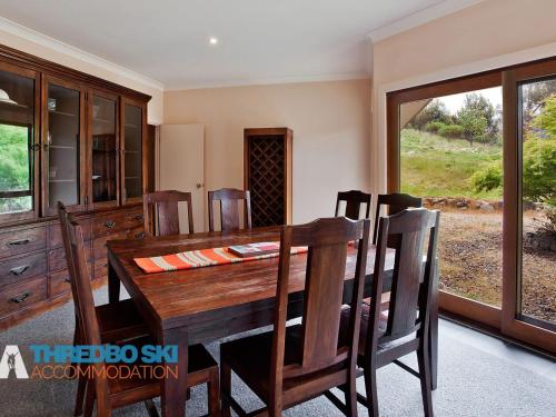 a dining room with a wooden table and chairs at The Little Nap in Crackenback