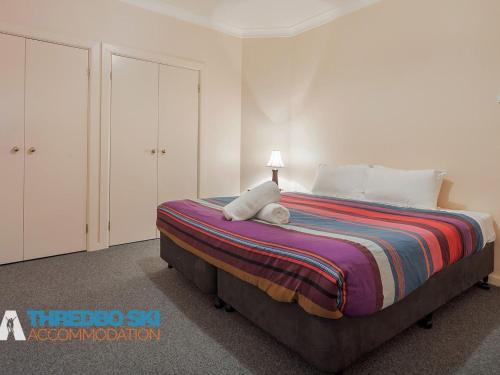 a bedroom with a bed with a stuffed animal on it at The Little Nap in Crackenback