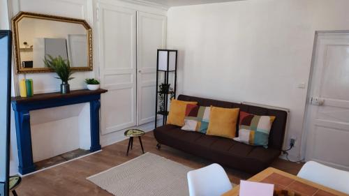 a living room with a couch and a mirror at Salardine Apartments - Cosy Suite in Châlus