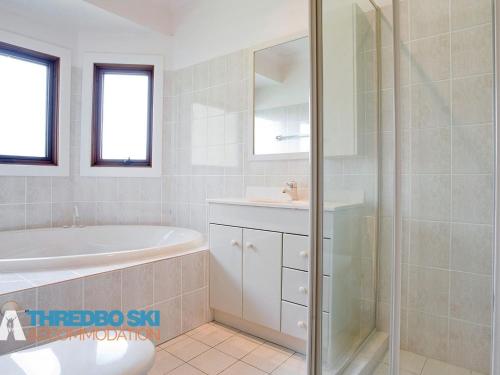 a bathroom with a tub and a sink and a shower at The Little Nap in Crackenback