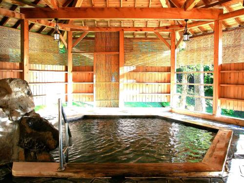 a swimming pool in a pavilion with water in it at Aomori Winery Hotel in Ōwani
