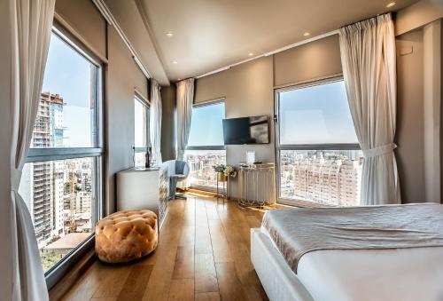 a bedroom with a bed and large windows at My Jerusalem View in Jerusalem