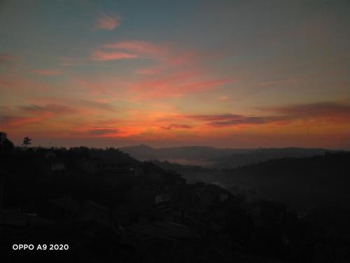 a sunset with the sun setting over the mountains at B&B Madonna degli Airali in Vezza d'Alba
