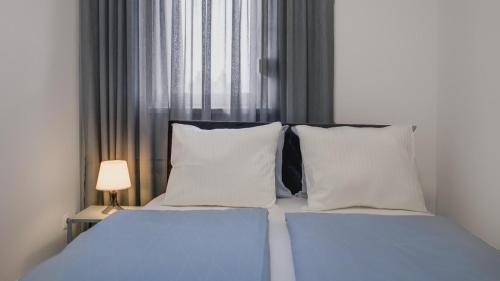 een slaapkamer met een bed met witte kussens en een raam bij Stylish Place near Park Maksimir with FREE parking in Zagreb