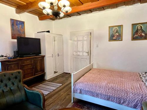 a bedroom with a bed and a flat screen tv at Róza Vendégház in Buják