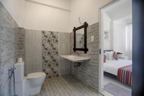 uma casa de banho com uma cama, um WC e um lavatório. em Dazzle Bay by Twenty Two em Weligama