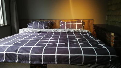 a bedroom with a bed with a blue and white comforter at Hohhot Hanggai International Youth Hostel in Hohhot