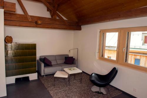 a living room with a couch and a chair at Chasa Tablà Guarda in Guarda