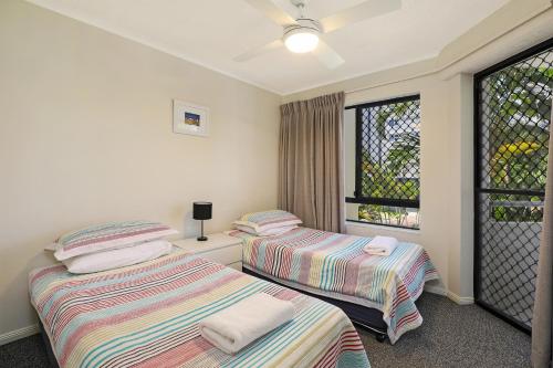 two beds in a room with a window at Spinnaker Quays in Mooloolaba