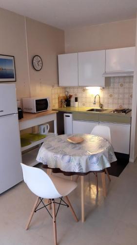 - une cuisine avec une table, une table et des chaises dans l'établissement Studio Masol avec balcon, à Amélie-les-Bains-Palalda