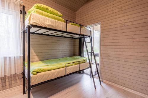 a room with two bunk beds in a wooden wall at Bona Natura Nameliai in Bražuolė