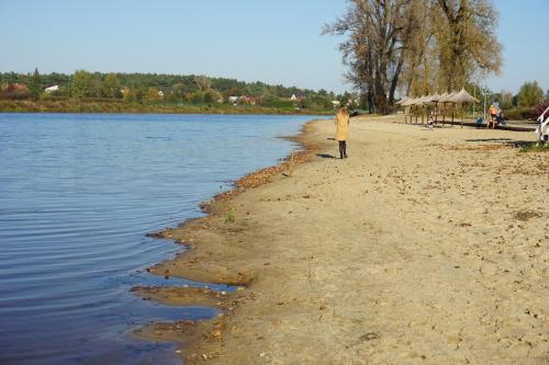 a person standing on a beach next to the water at Wyspa Wisła Przyjazna Przystań Stężyca in Stężyca