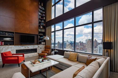 a living room with a couch and a large window at InterContinental New York Times Square by IHG in New York