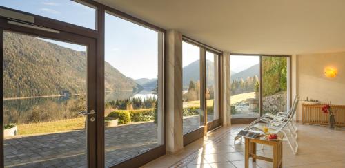 a room with a view of a lake and mountains at Hotel Nagglerhof am Weissensee in Weissensee