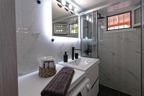 La salle de bains est pourvue d'un lavabo, d'un miroir et d'une baignoire. dans l'établissement Avlaki Getaway Villa, à Pórto Ráfti