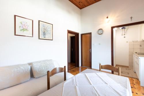ein Wohnzimmer mit einer weißen Couch und einem Tisch in der Unterkunft Marica A2 - Nr 1 in Baška