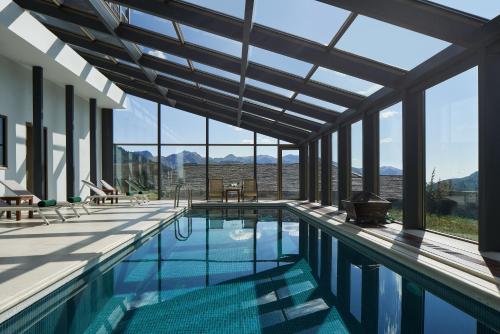 a large swimming pool with a large window at Grand Forest Metsovo - Small Luxury Hotels of the World in Metsovo