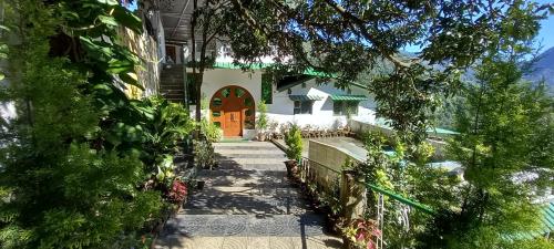 a house with a walkway leading to a door at Experto The Greens in Nainital