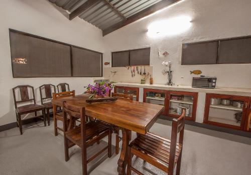 una cucina con tavolo in legno e alcune sedie di Joao's Place a Vila Praia Do Bilene