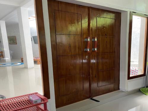 eine Holztür in einem Zimmer mit Fenster in der Unterkunft Linz Beach House in Pasanggaran