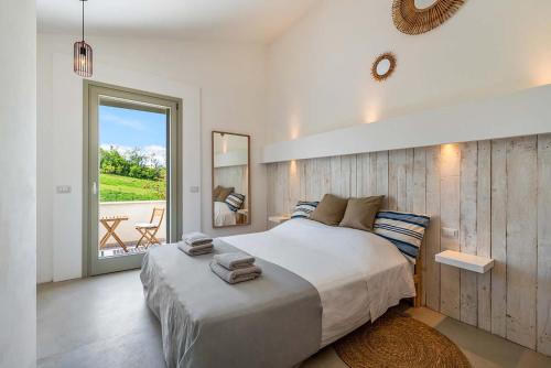 ein Schlafzimmer mit einem großen Bett und einem Balkon in der Unterkunft Casa Luce in Torre di Palme