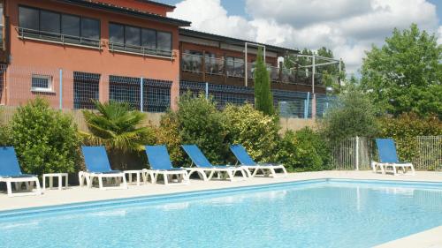 a group of lounge chairs and a swimming pool at ibis Budget Millau Viaduc in Millau