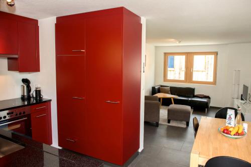 a red cabinet in a kitchen with a living room at Chasa Tablà Guarda in Guarda