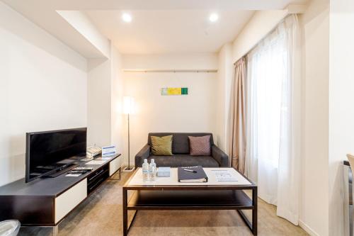 a living room with a couch and a tv at Pangoo Shinagawa in Tokyo