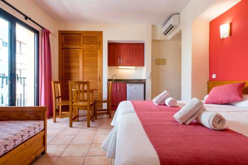 une chambre d'hôtel avec deux lits et une cuisine dans l'établissement Apartamentos Casa Maria, à Sant Antoni de Portmany