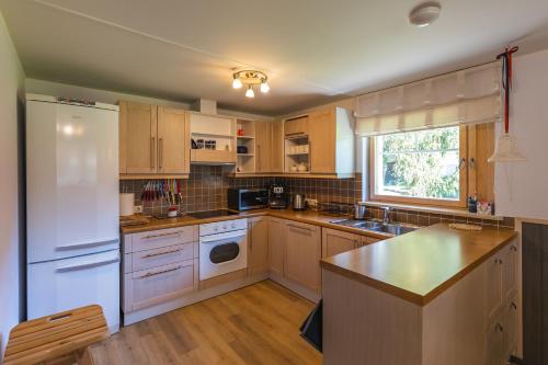 a kitchen with wooden cabinets and a white refrigerator at Nuutri Villa in Kärdla