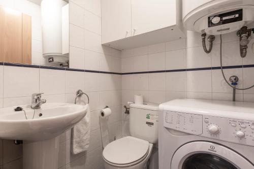 a bathroom with a washing machine and a sink at Outdoor Apartaments - Comfort in Andorra la Vella