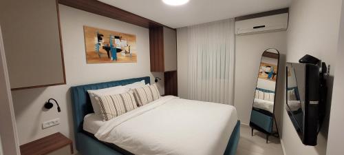 - une petite chambre avec un lit et un miroir dans l'établissement sea side eilat holiday apartment, à Eilat