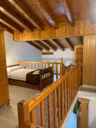 1 dormitorio con 1 cama y escalera de madera en ABELLETES - K31 Deusol - Vall d'Incles - Soldeu, en Incles