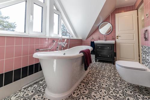 a bathroom with a tub and a toilet and a sink at Tiismani Villa in Kärdla