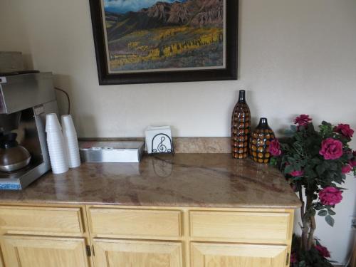 a kitchen with a counter top with a picture on the wall at Scottish Inn Winnemucca in Winnemucca