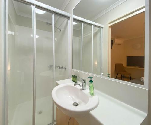 uma casa de banho branca com um lavatório e um chuveiro em Lake Tyrrell Accommodation LTA em Sea Lake