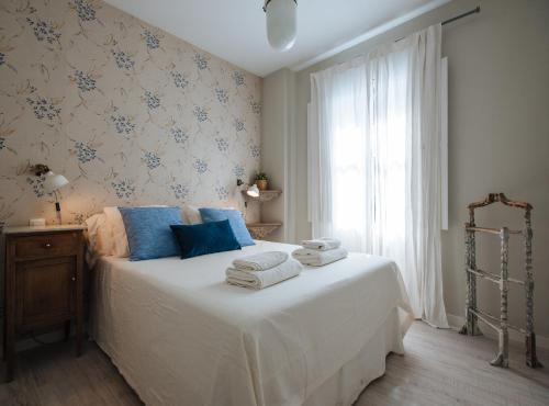 1 dormitorio con 1 cama con toallas en Latidos de Sevilla I - Deluxe con piscina en Sevilla